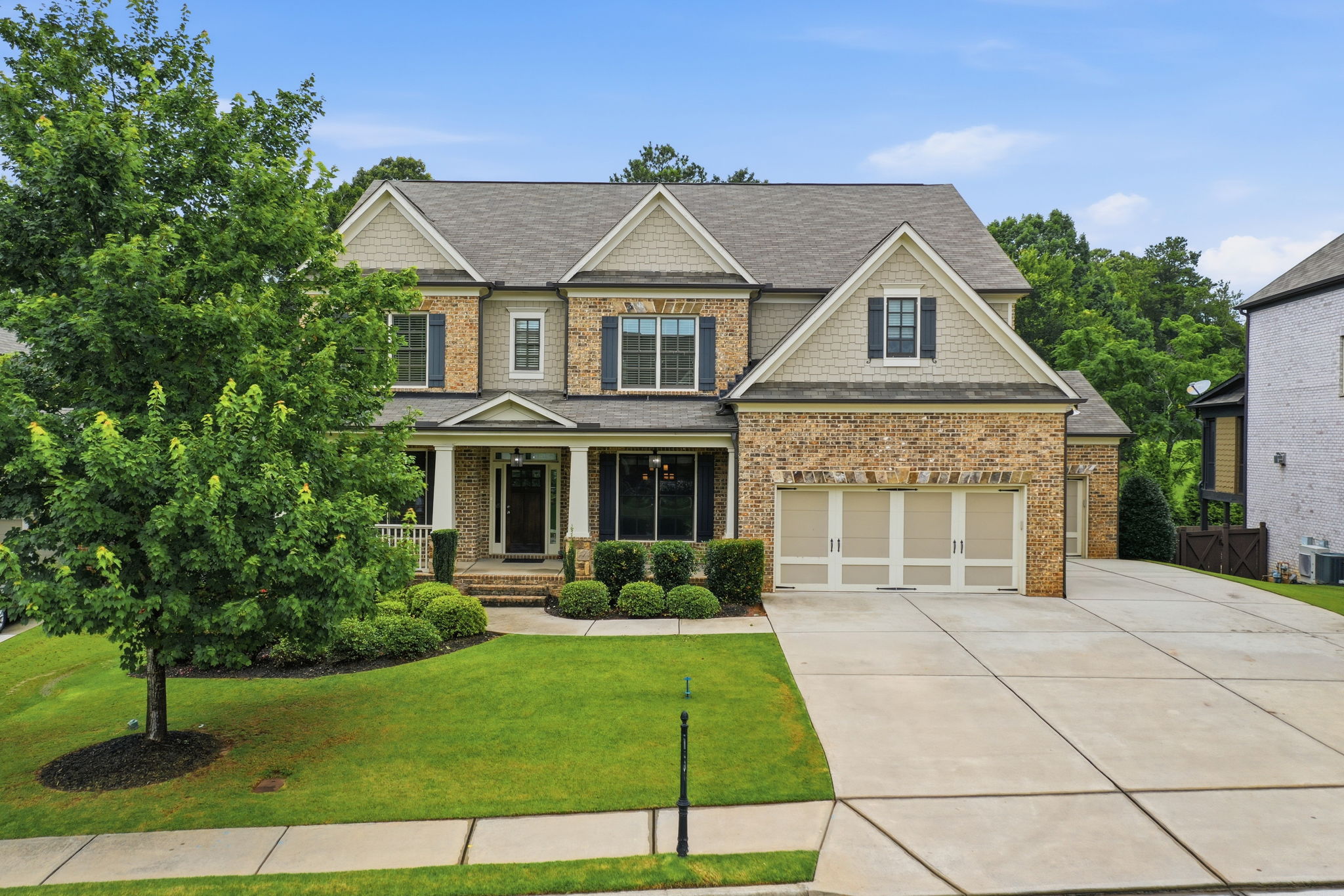 Front exterior of 3342 Laurel Leaf Way, a luxury 6-bedroom brick home with a finished basement and heated gunite pool in Laurel Manor, Buford, Georgia, listed by Reed Real Estate.