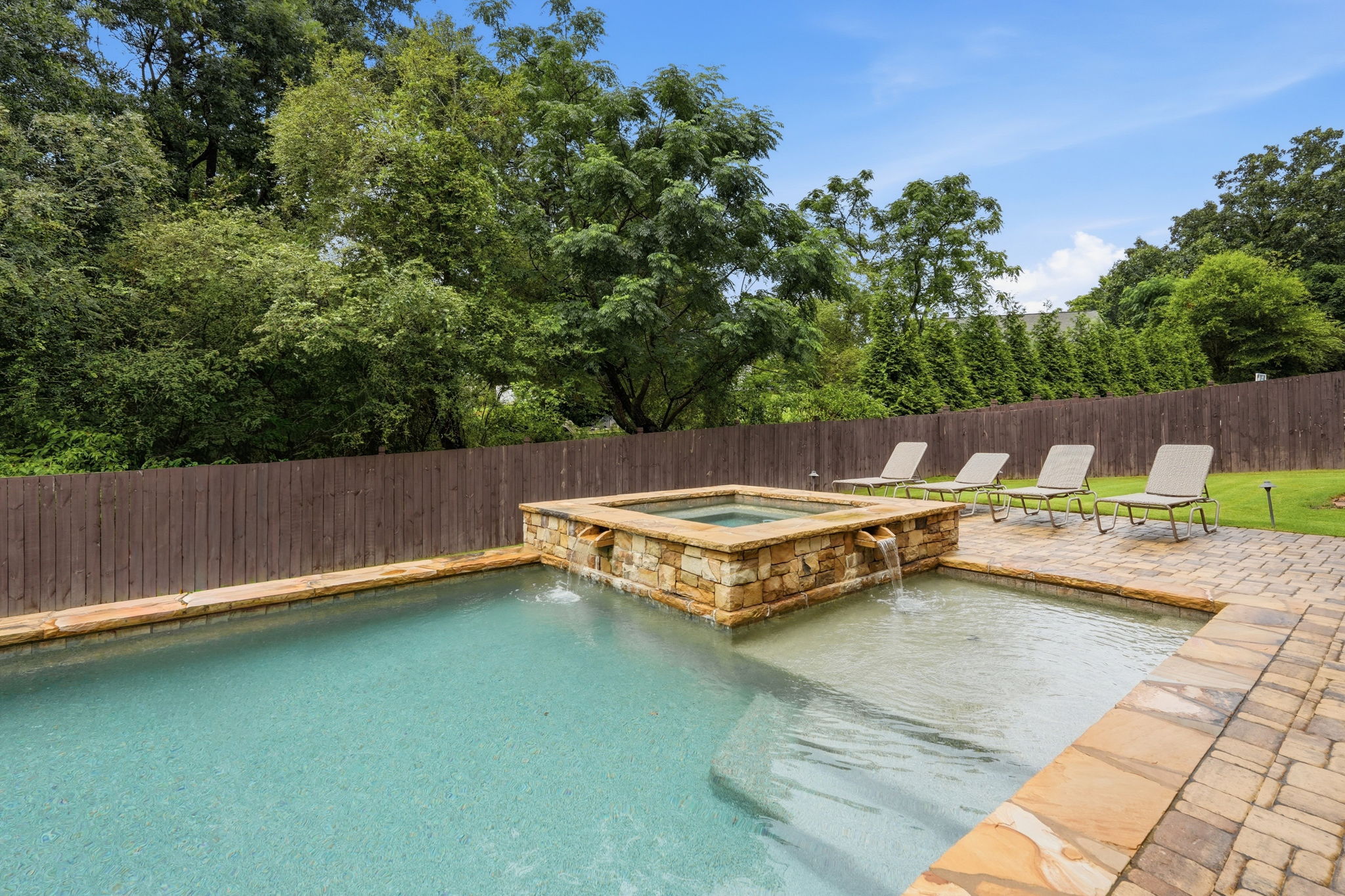 Heated gunite swimming pool with attached spa and private backyard at 3342 Laurel Leaf Way in Laurel Manor, Buford, Georgia.